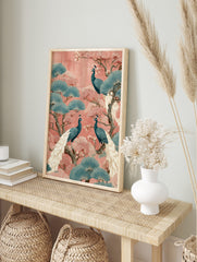 Illustrative wall art print with three teal peacocks, pink blossoms, and blue fan-shaped, in an alternate framed mockup