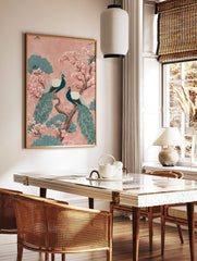 Two teal peacocks on a brown branch with pink cherry blossoms and teal foliage on a pink background, in a styled room mockup