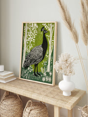 Black peacock with white feather details in green woodland linocut style print, in an alternate framed mockup