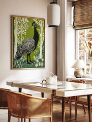 Black peacock with white feather details in green woodland linocut style print, in a styled room mockup