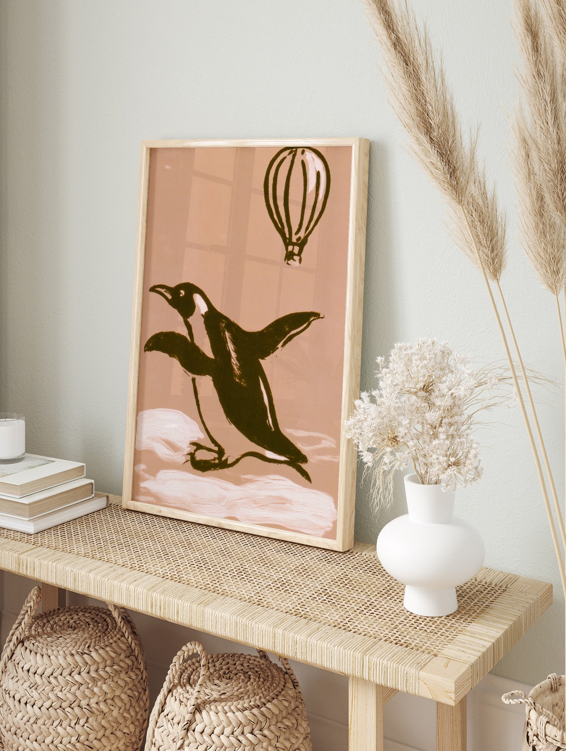 Illustrative penguin and hot air balloon art print on a warm beige background, in an alternate framed mockup