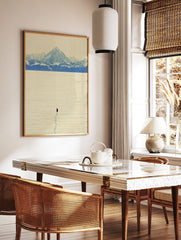 Minimalist art print of a lone black penguin on textured ice with blue and white snow mountains in, in a styled room mockup