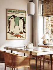 Illustrative print of two black and white penguins facing each other, with an orange fish on the ice, in a styled room mockup