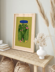 Illustrative jar of pickles with green cucumbers and dill on olive green background, in an alternate framed mockup