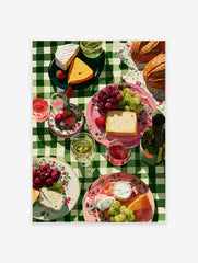 Picnic wall art illustration with cheese, grapes, strawberries, bread, and wine on a green checkered tablecloth.