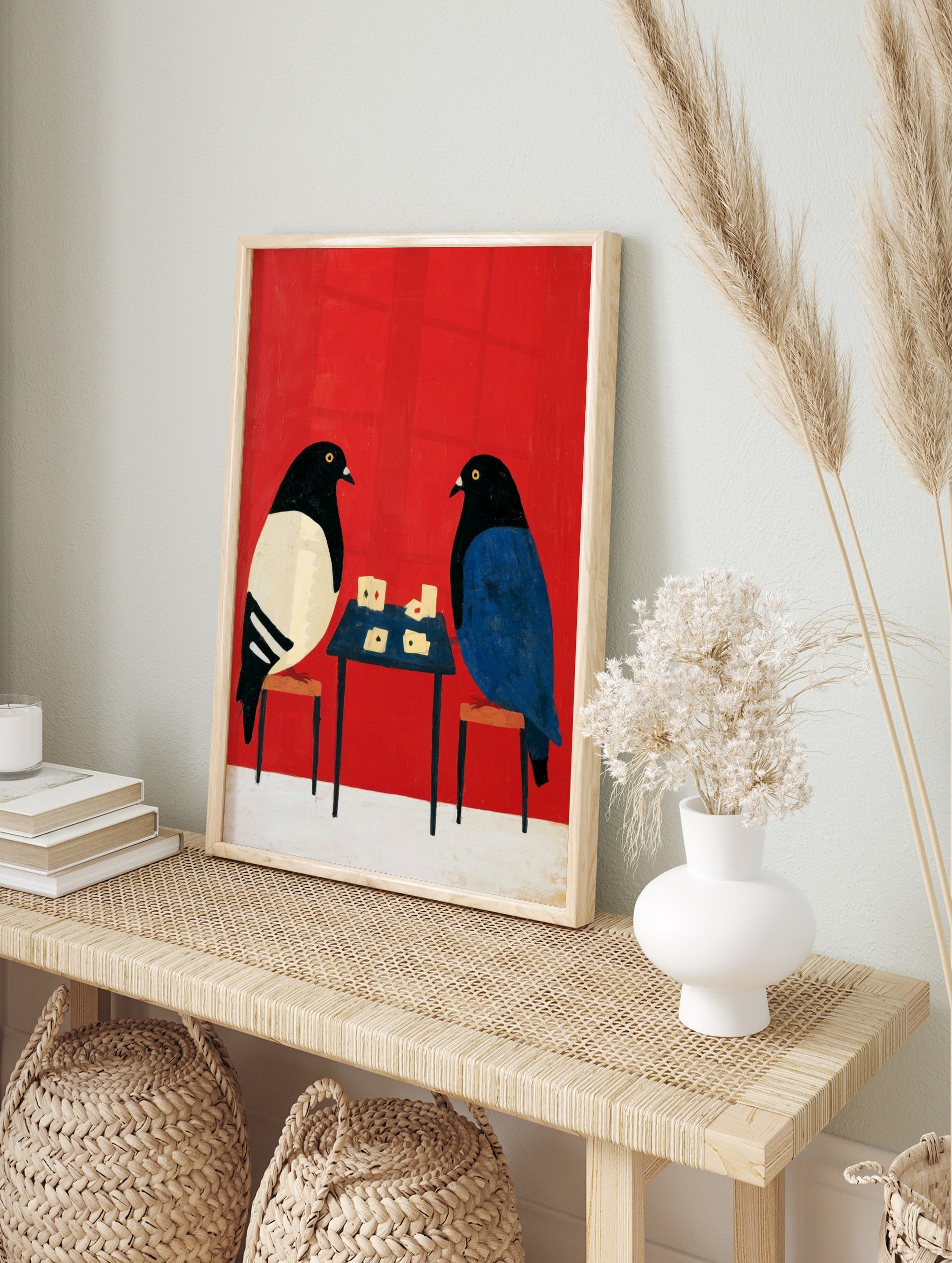 Stylised illustration of two pigeons playing cards on a small table against a solid vibrant, in an alternate framed mockup