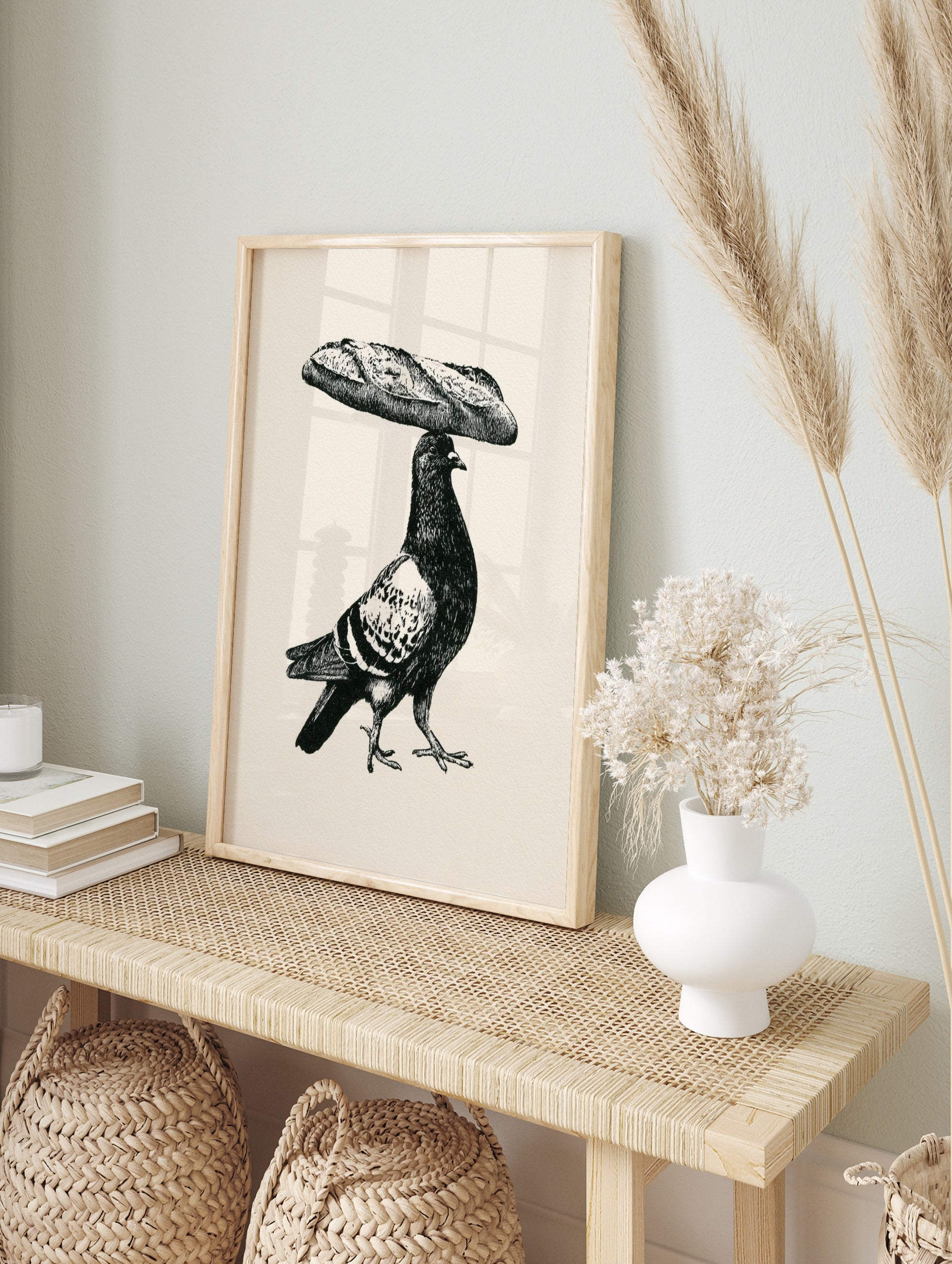 Black and white illustrative art print of a pigeon balancing a baguette on its head on a, in an alternate framed mockup