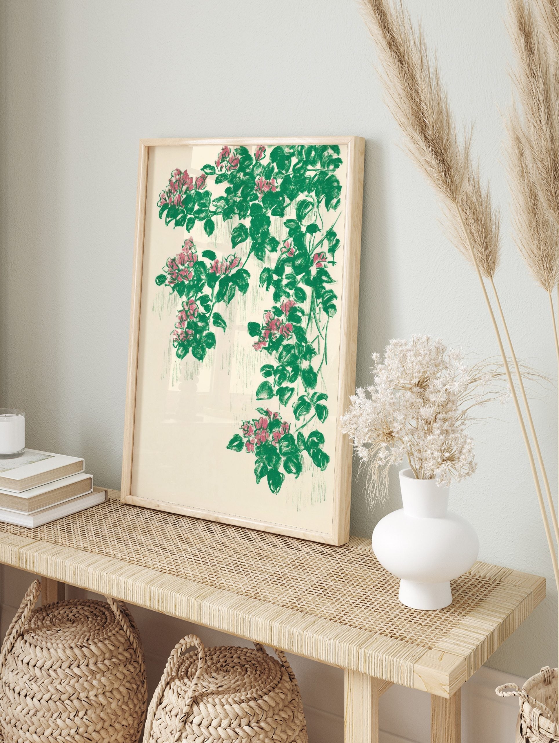 Illustrative botanical print with cascading pink flowers and green leaves on a cream, in an alternate framed mockup
