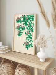 Illustrative botanical print with cascading pink flowers and green leaves on a cream, in an alternate framed mockup