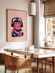 Illustrative print of a pink Buddha figure wearing black headphones against a light pink background, in a styled room mockup