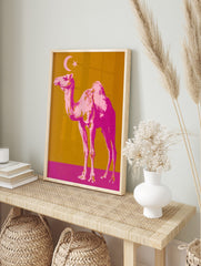 Pop art style print of a pink camel with a crescent moon and star on a golden-orange and, in an alternate framed mockup