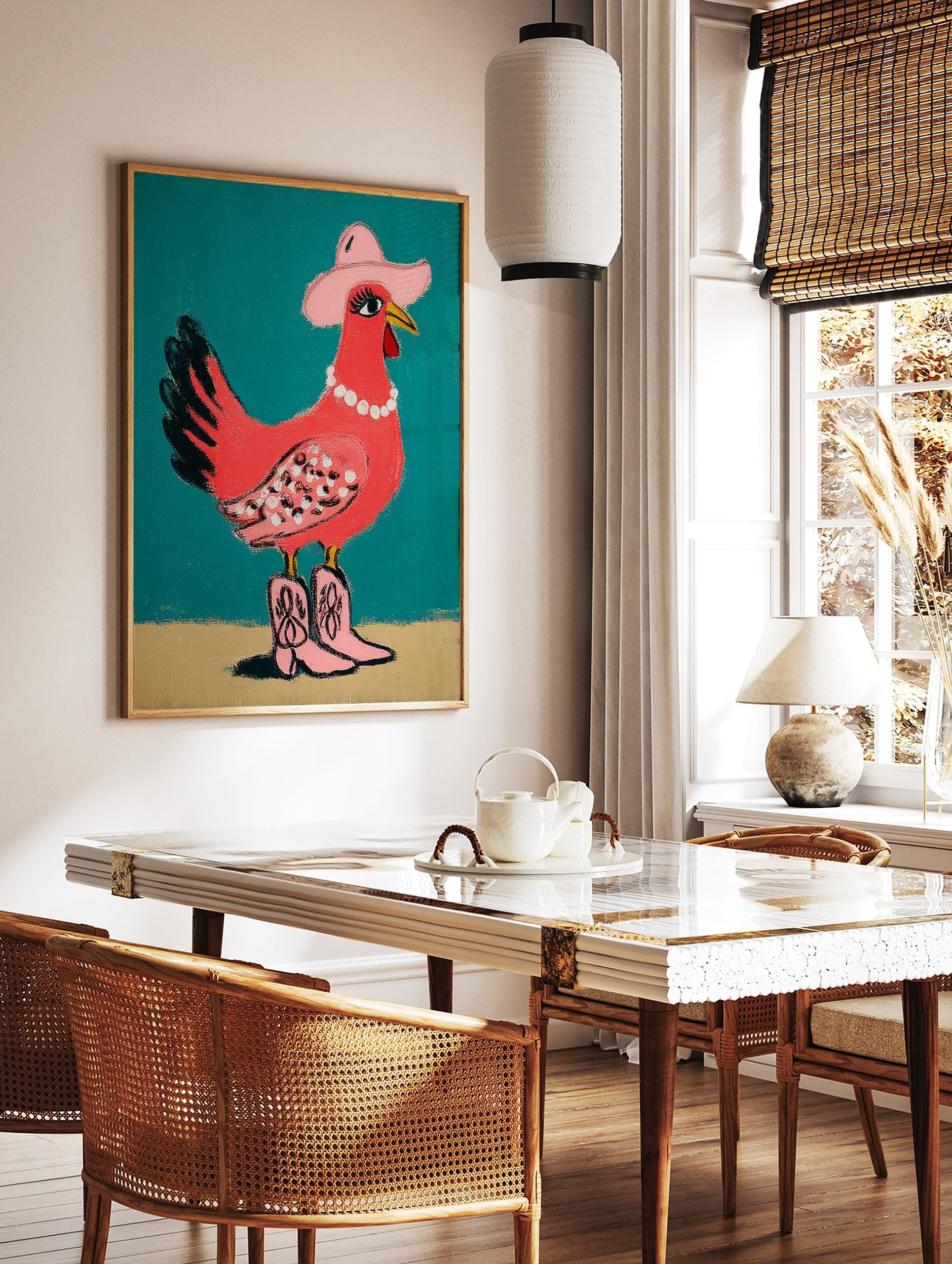 Pink chicken illustration wearing a cowboy hat, pearl necklace, and pink cowboy boots on a teal, in a styled room mockup
