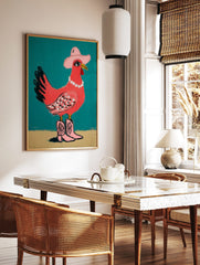 Pink chicken illustration wearing a cowboy hat, pearl necklace, and pink cowboy boots on a teal, in a styled room mockup