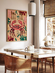 Illustrative wall art print of a pink crab with cutlery and foliage on a beige background, in a styled room mockup