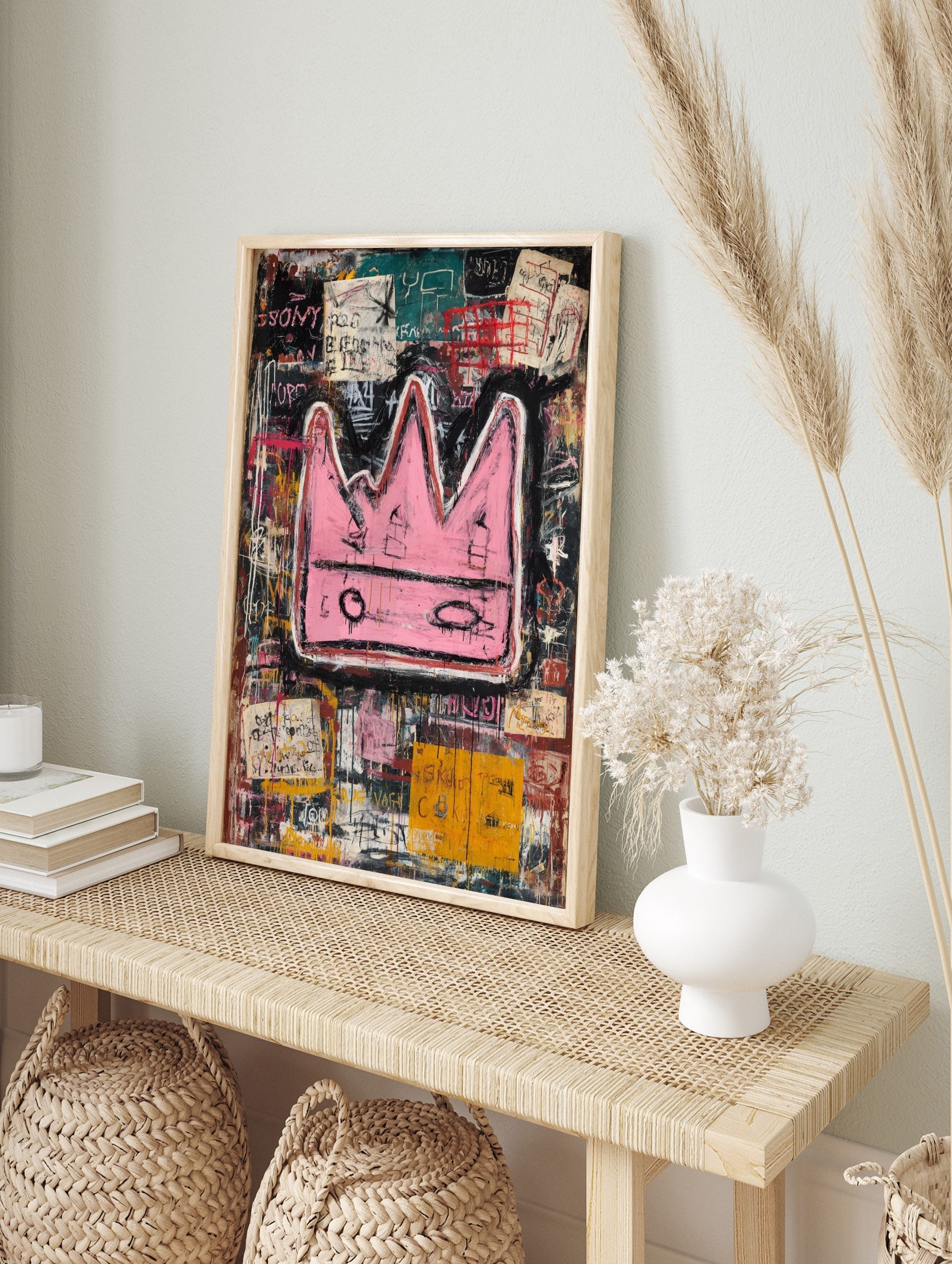 Bold pink crown with black outlines on a layered, abstract background of black, teal, and, in an alternate framed mockup