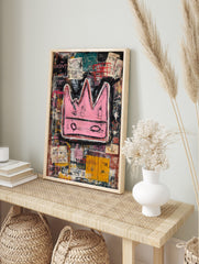 Bold pink crown with black outlines on a layered, abstract background of black, teal, and, in an alternate framed mockup