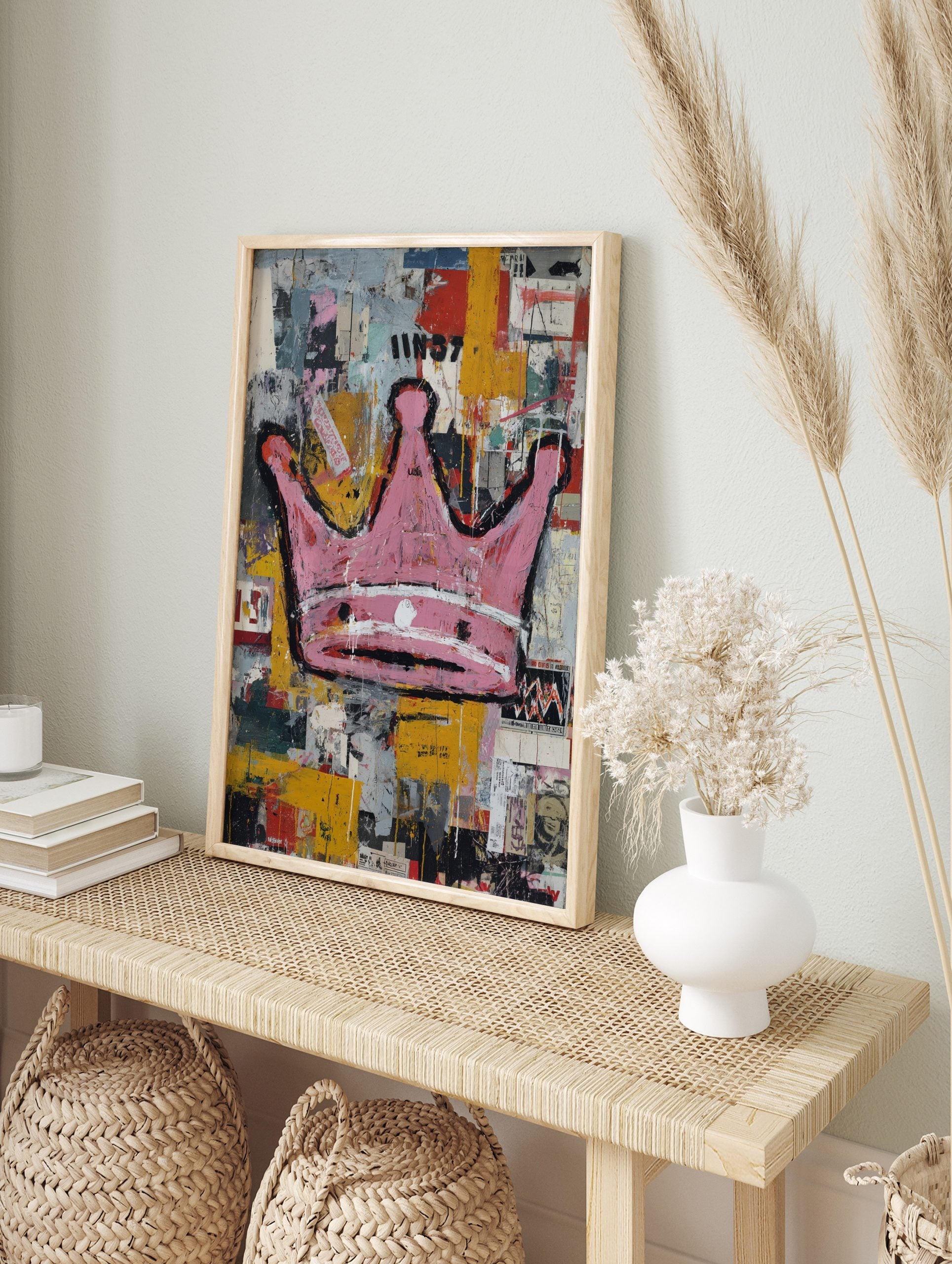 Pink crown with black outlines on a distressed, multi-colour street art background with text, in an alternate framed mockup