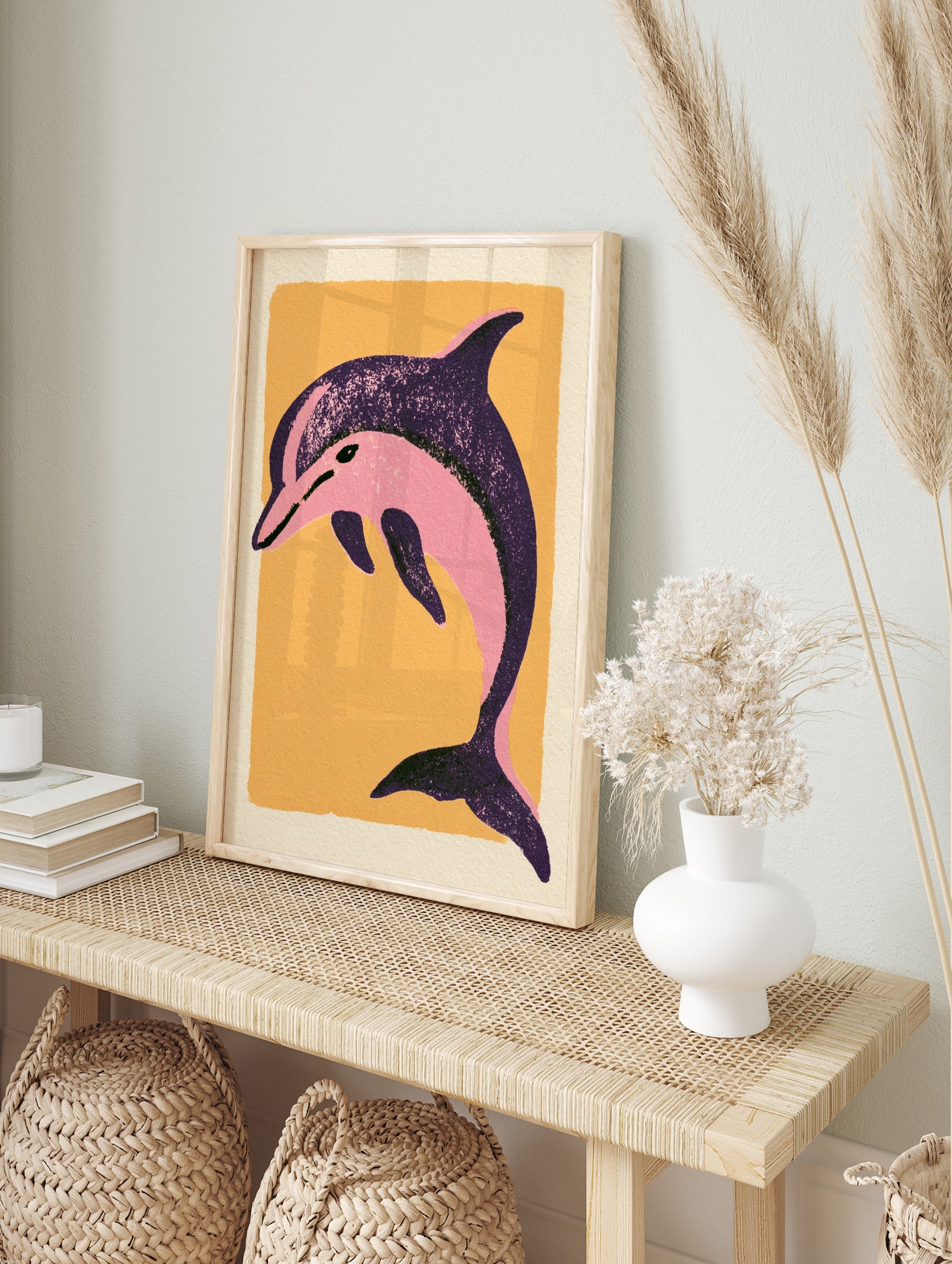 Stylized pink dolphin illustration on a textured orange background, illustrative sea animal, in an alternate framed mockup