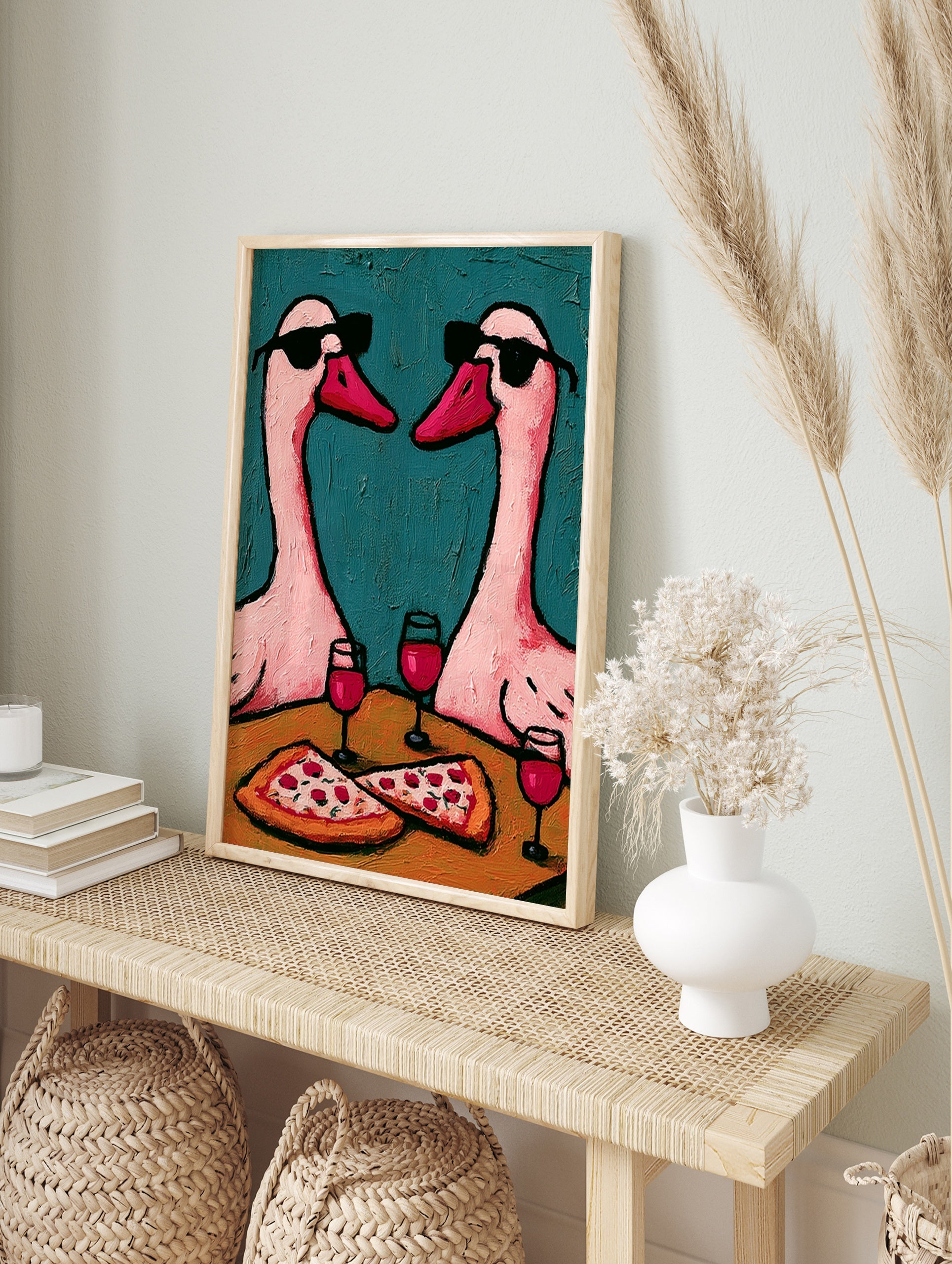 Illustration of two pink geese wearing sunglasses sharing pizza and red wine against a, in an alternate framed mockup