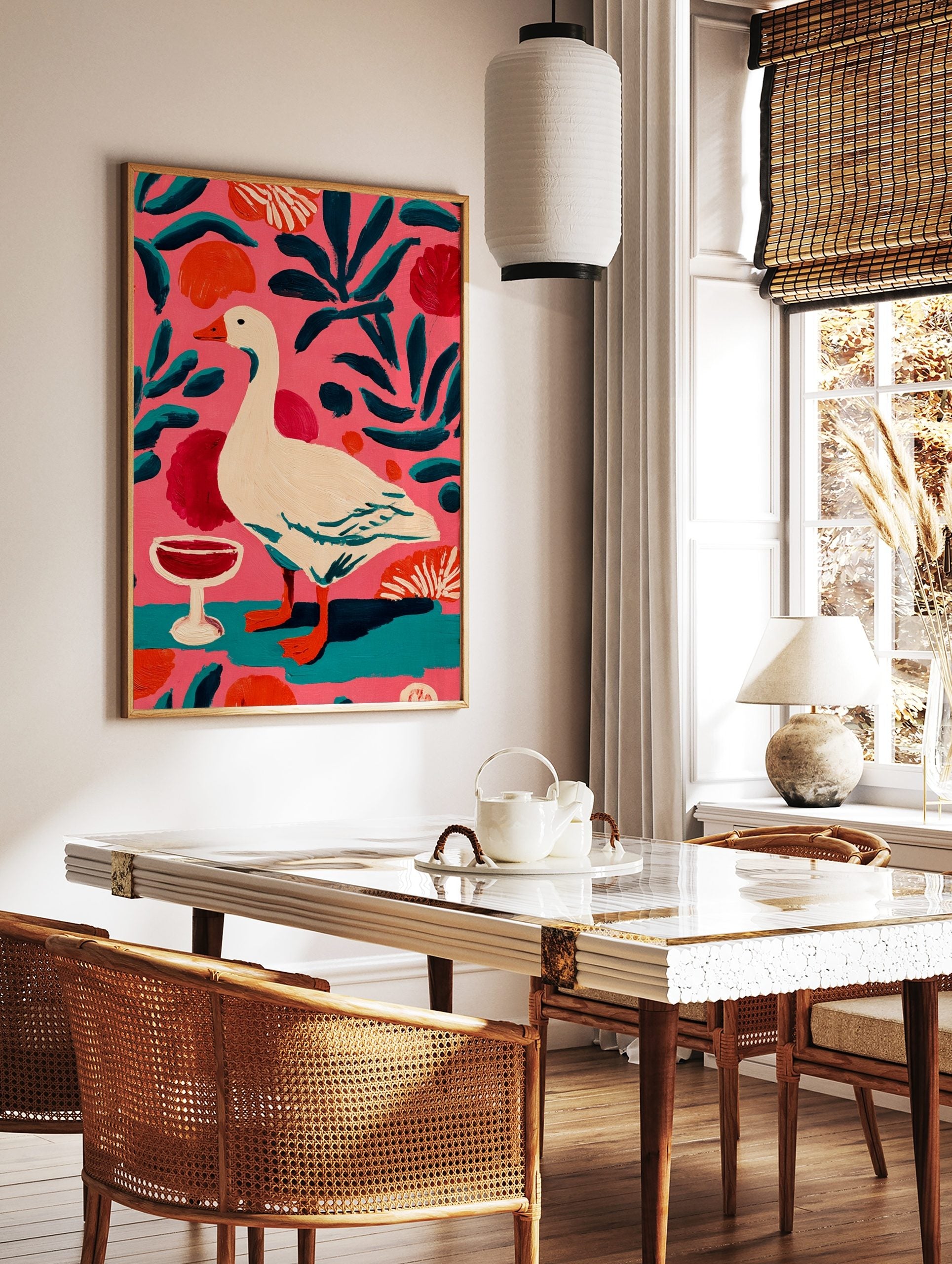 Illustrative painting of a white goose with orange beak, red wine glass, and teal leaves on a pink, in a styled room mockup