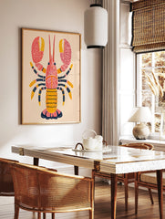 Illustrative pink and yellow lobster wall art print with dark blue patterned legs and red dots, in a styled room mockup