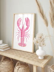 Pink lobster watercolour illustration art print with white speckles on a plain white, in an alternate framed mockup