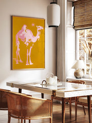 Pink pop art camel with crescent moon on hump and star on golden yellow background, in a styled room mockup