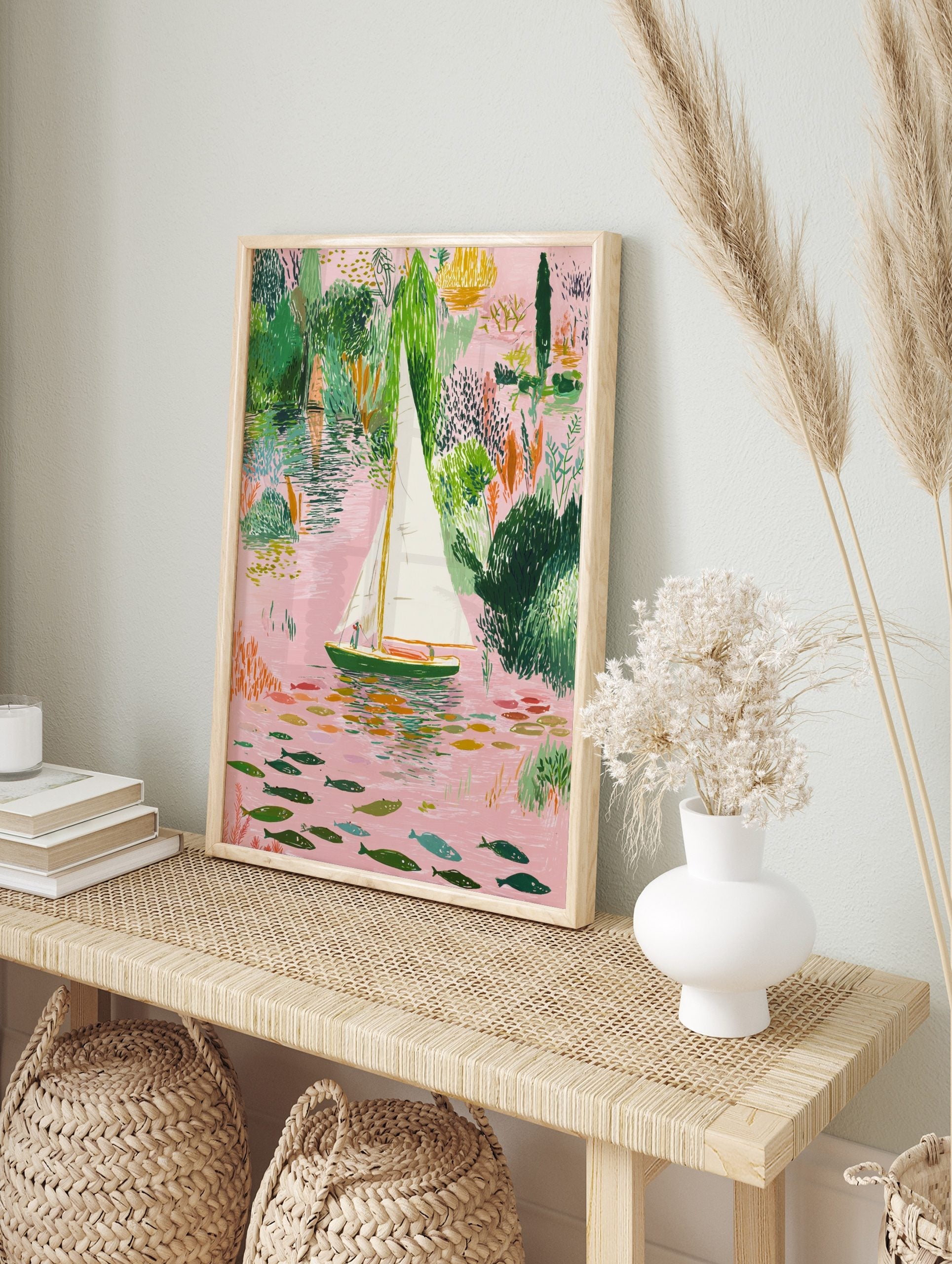 Illustrative sailboat on a pink river with green foliage and colourful fish art print, in an alternate framed mockup