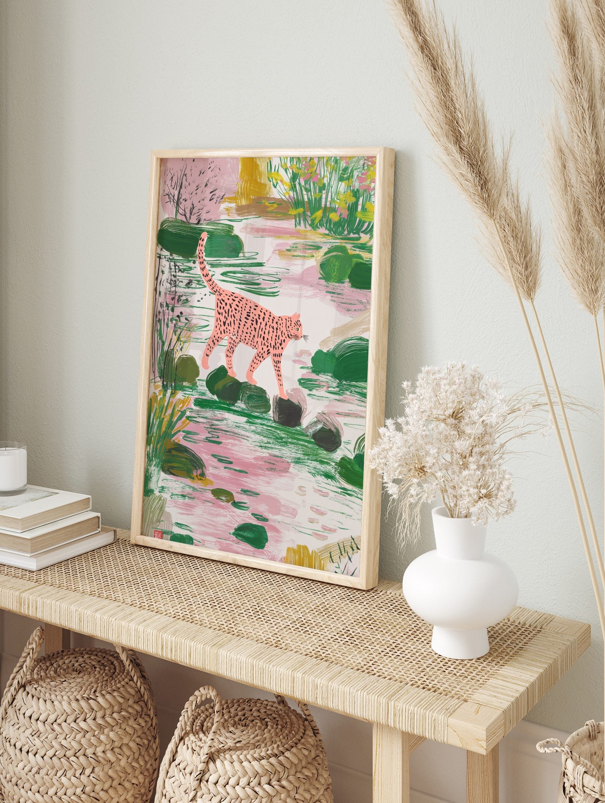 Pink spotted leopard walking on stepping stones in a lush green and pink pond scene, in an alternate framed mockup