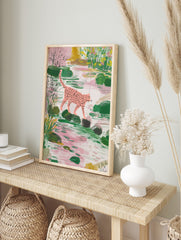 Pink spotted leopard walking on stepping stones in a lush green and pink pond scene, in an alternate framed mockup