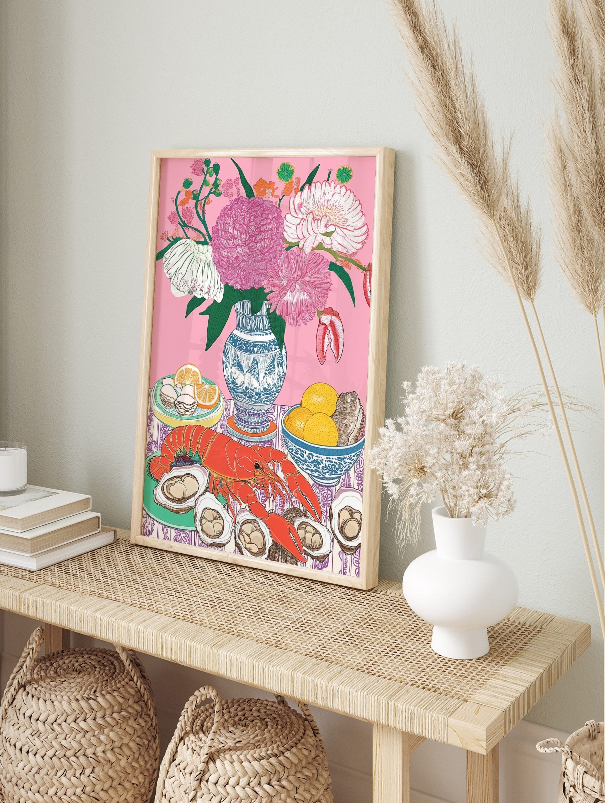 Still life illustration of red lobster, oysters, lemons, and pink flowers in blue vase on, in an alternate framed mockup
