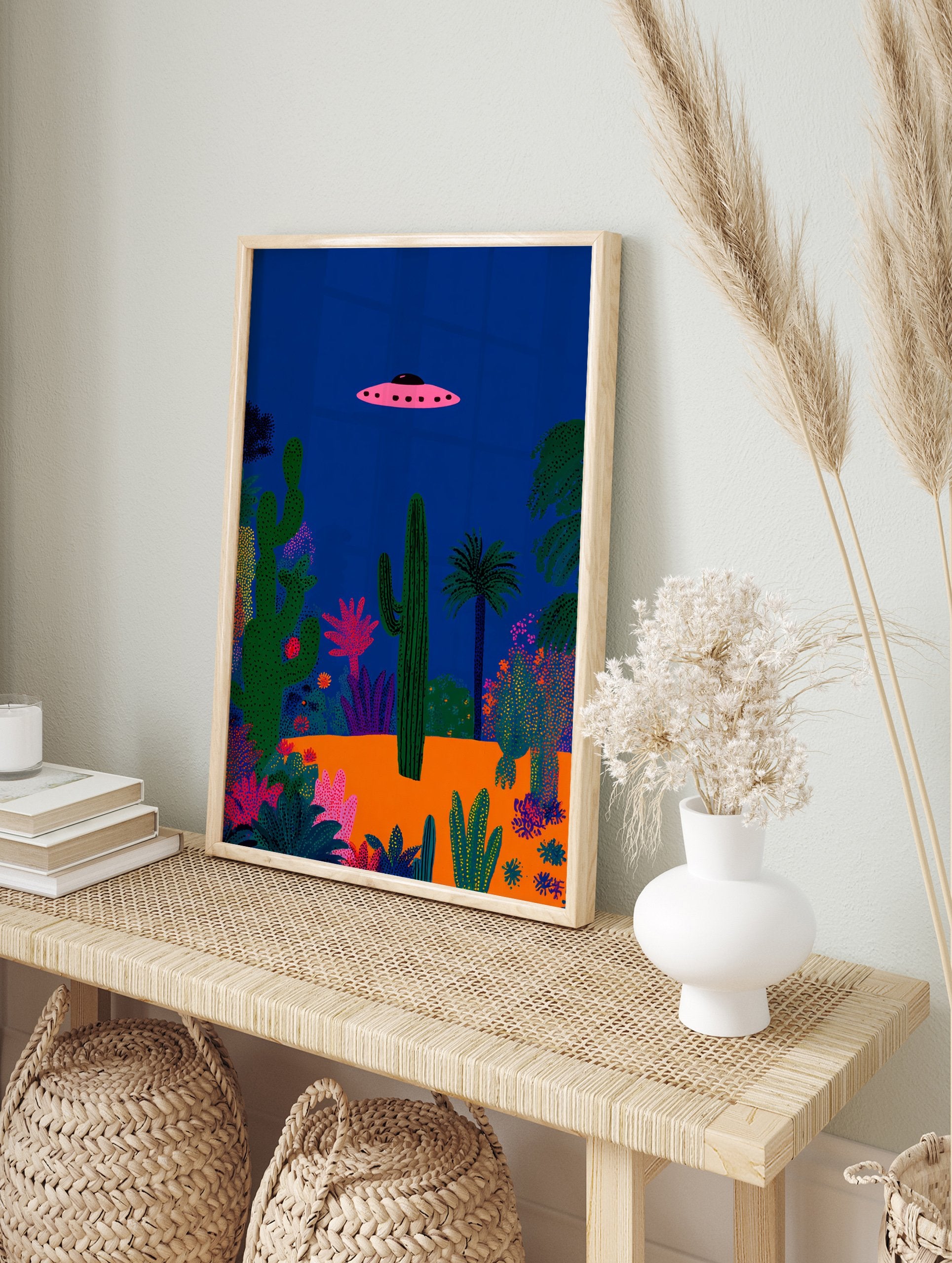 Pink UFO flying over a vibrant desert landscape with various green cacti and plants under a deep blue night sky poster. - Image 4