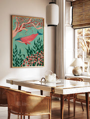 Pink whale swimming among red botanical flowers and green seaweed on a turquoise background, in a styled room mockup