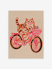 Illustrative print of an orange tabby cat riding a pink and red bicycle with a striped basket