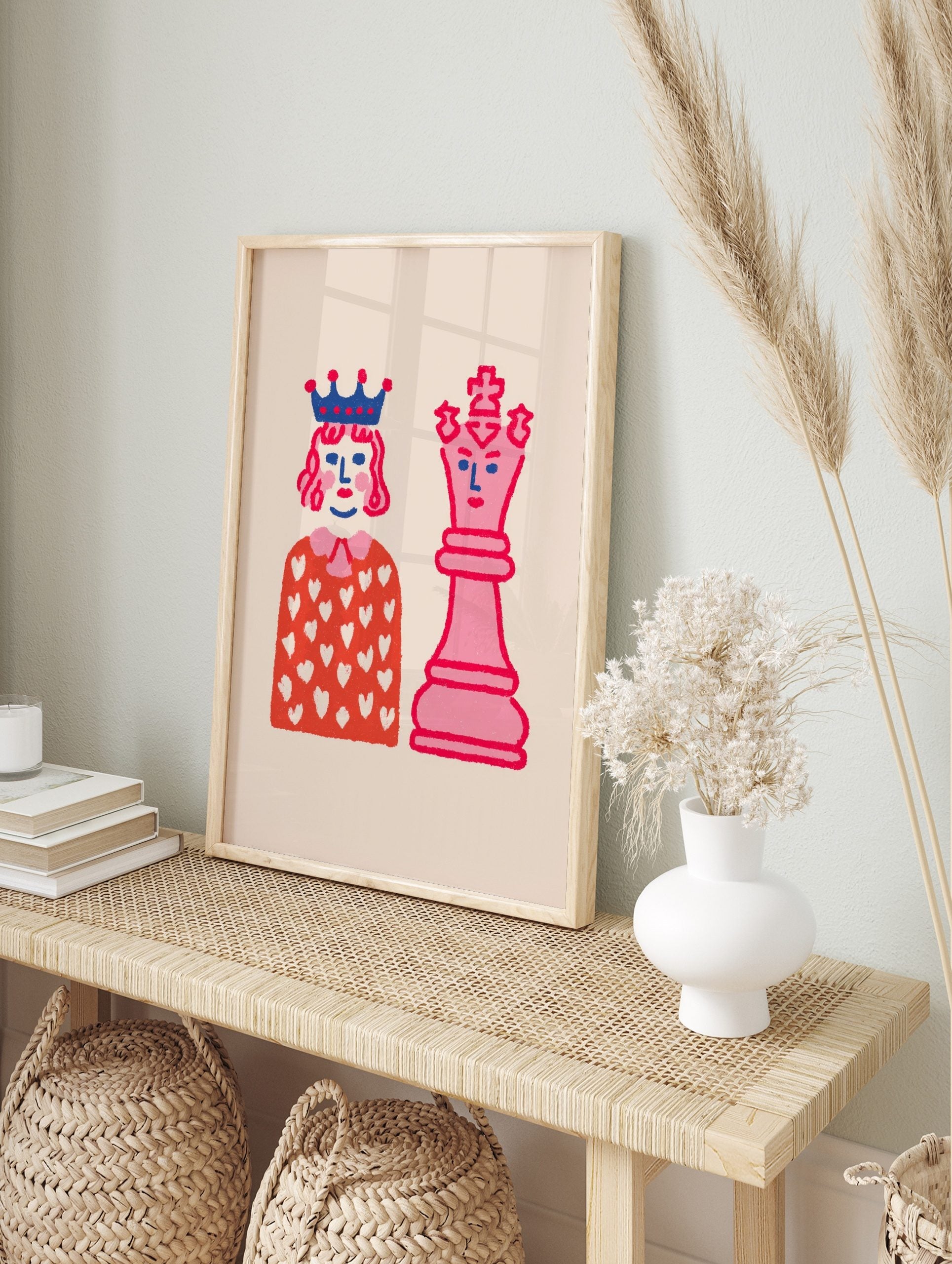 Playful illustrative wall art featuring a pink chess queen and a crowned figure on a light, in an alternate framed mockup