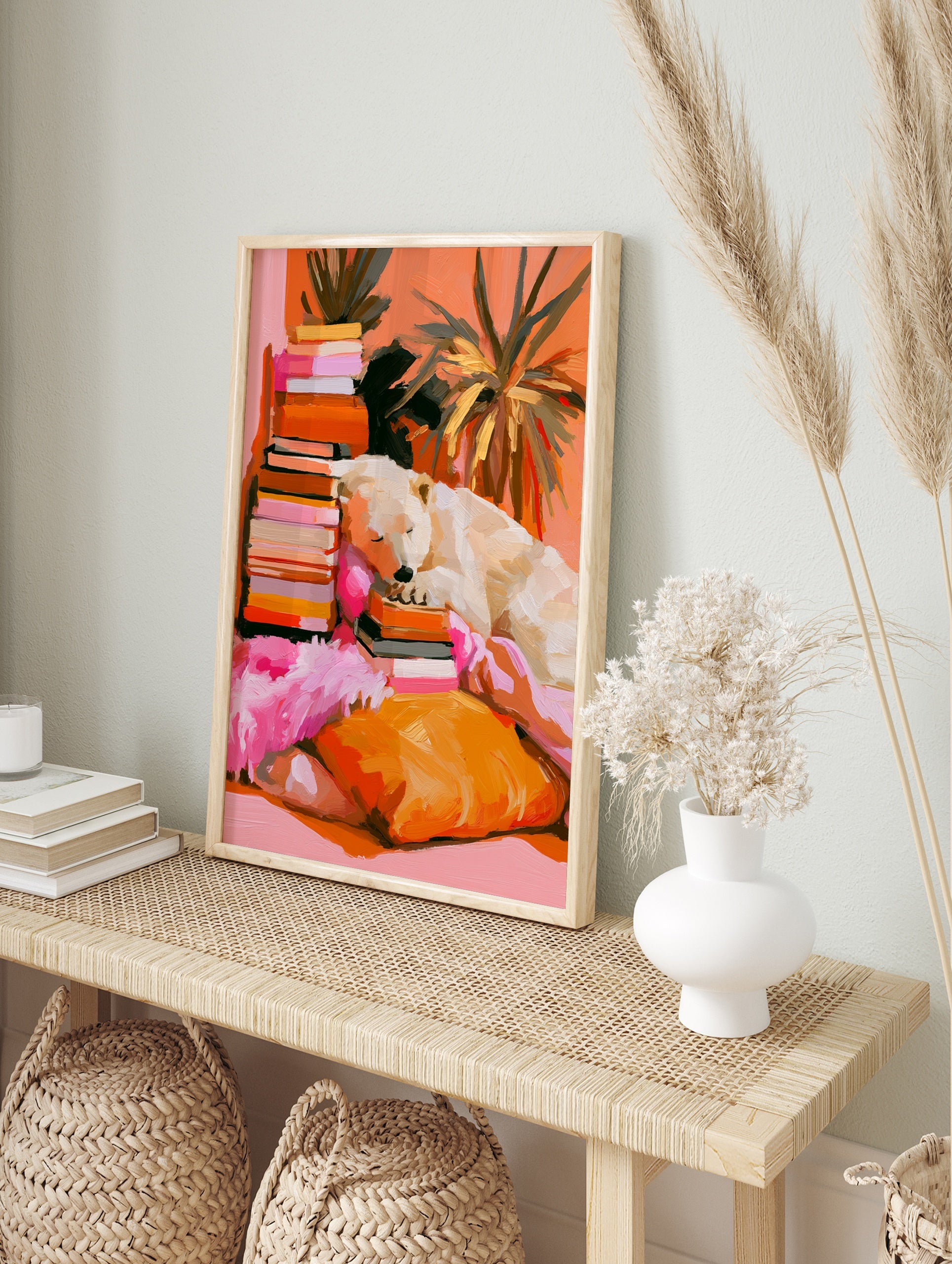 Painterly illustration of a polar bear sleeping on a stack of books with orange and pink tones, in an alternate framed mockup