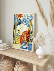 Sleeping polar bear in a yellow armchair with a red blanket, plants, and books, illustrative, in an alternate framed mockup