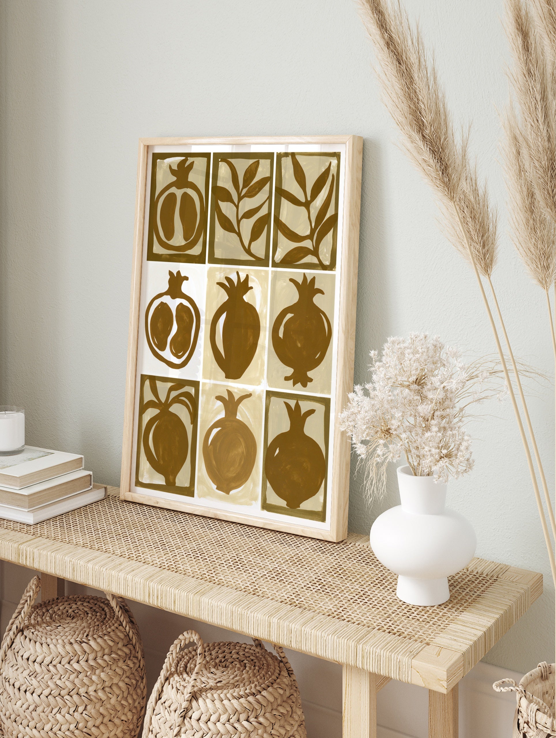 Nine-panel grid illustration of pomegranates and leaves in brown and beige on a paper print, in an alternate framed mockup