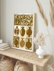 Nine-panel grid illustration of pomegranates and leaves in brown and beige on a paper print, in an alternate framed mockup