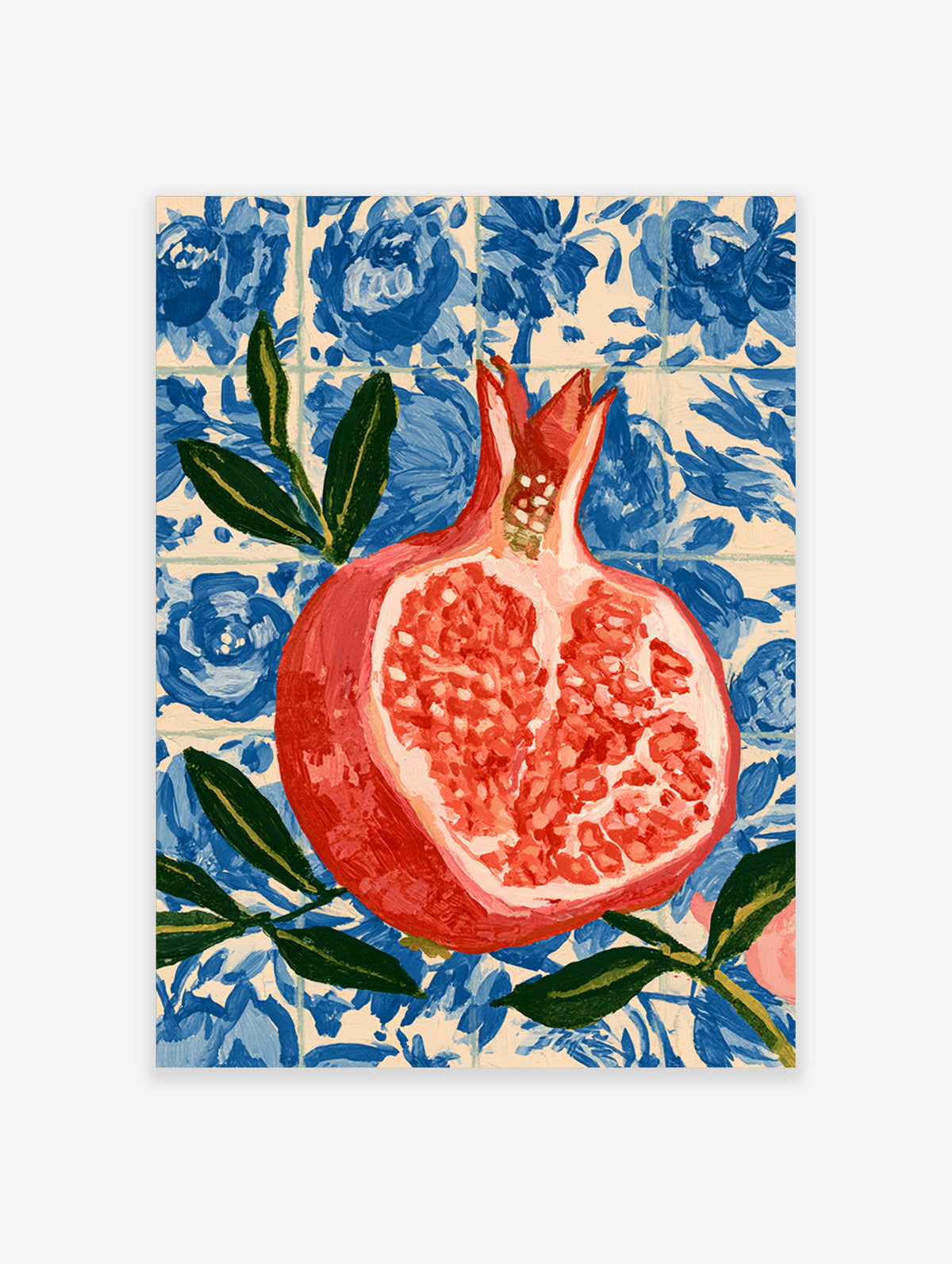 Halved pomegranate with red seeds and green leaves against a blue floral tile pattern
