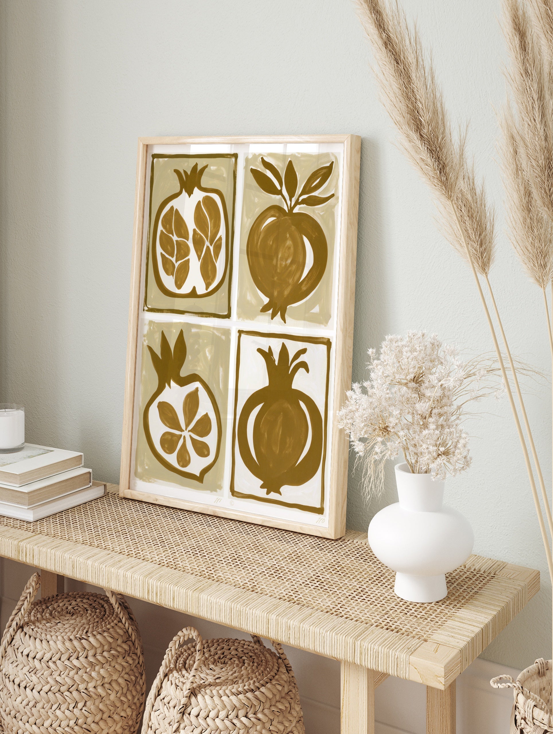 Four illustrative pomegranate prints in brown and tan, featuring whole fruit and, in an alternate framed mockup