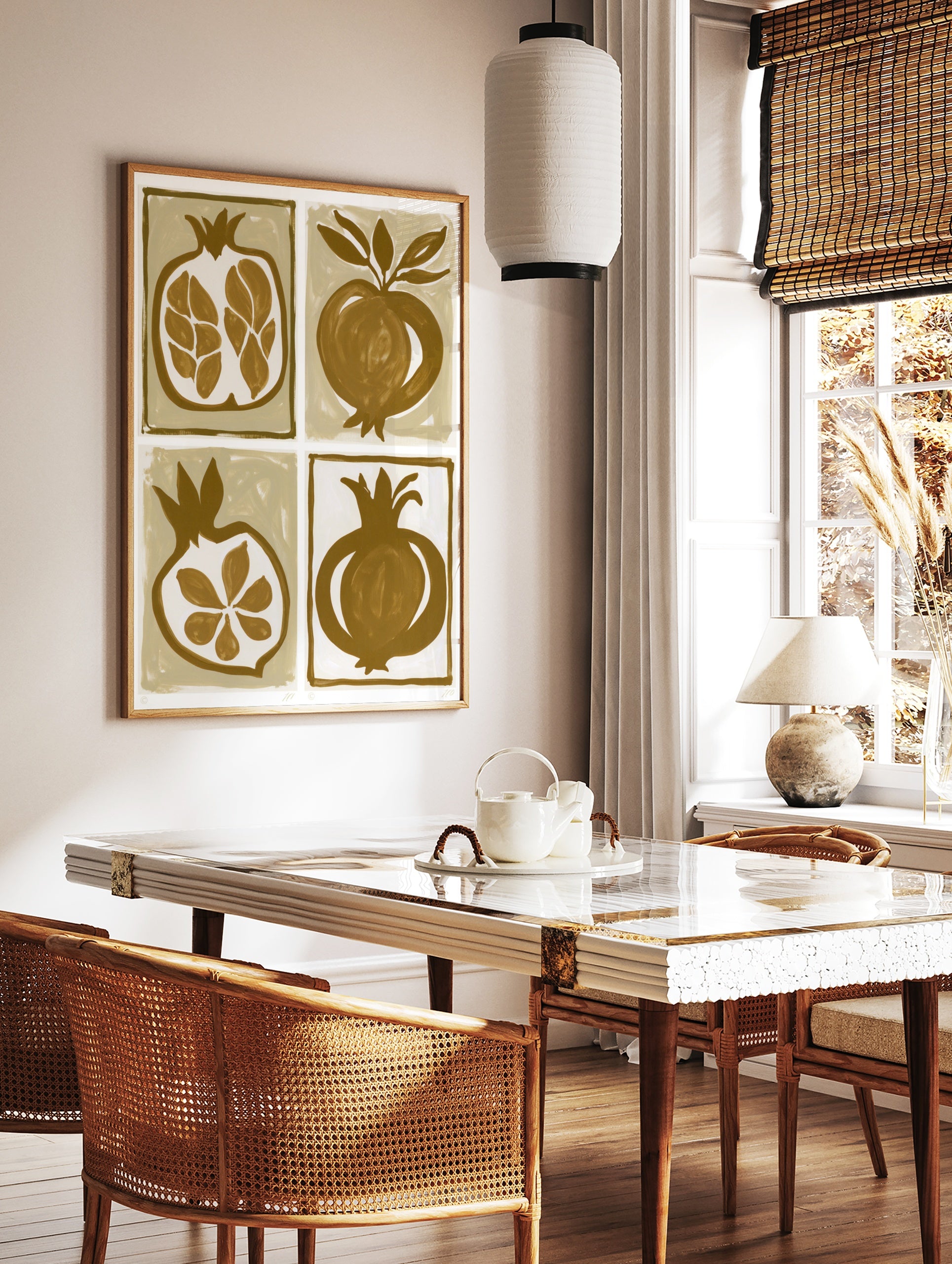 Four illustrative pomegranate prints in brown and tan, featuring whole fruit and cross-sections in, in a styled room mockup