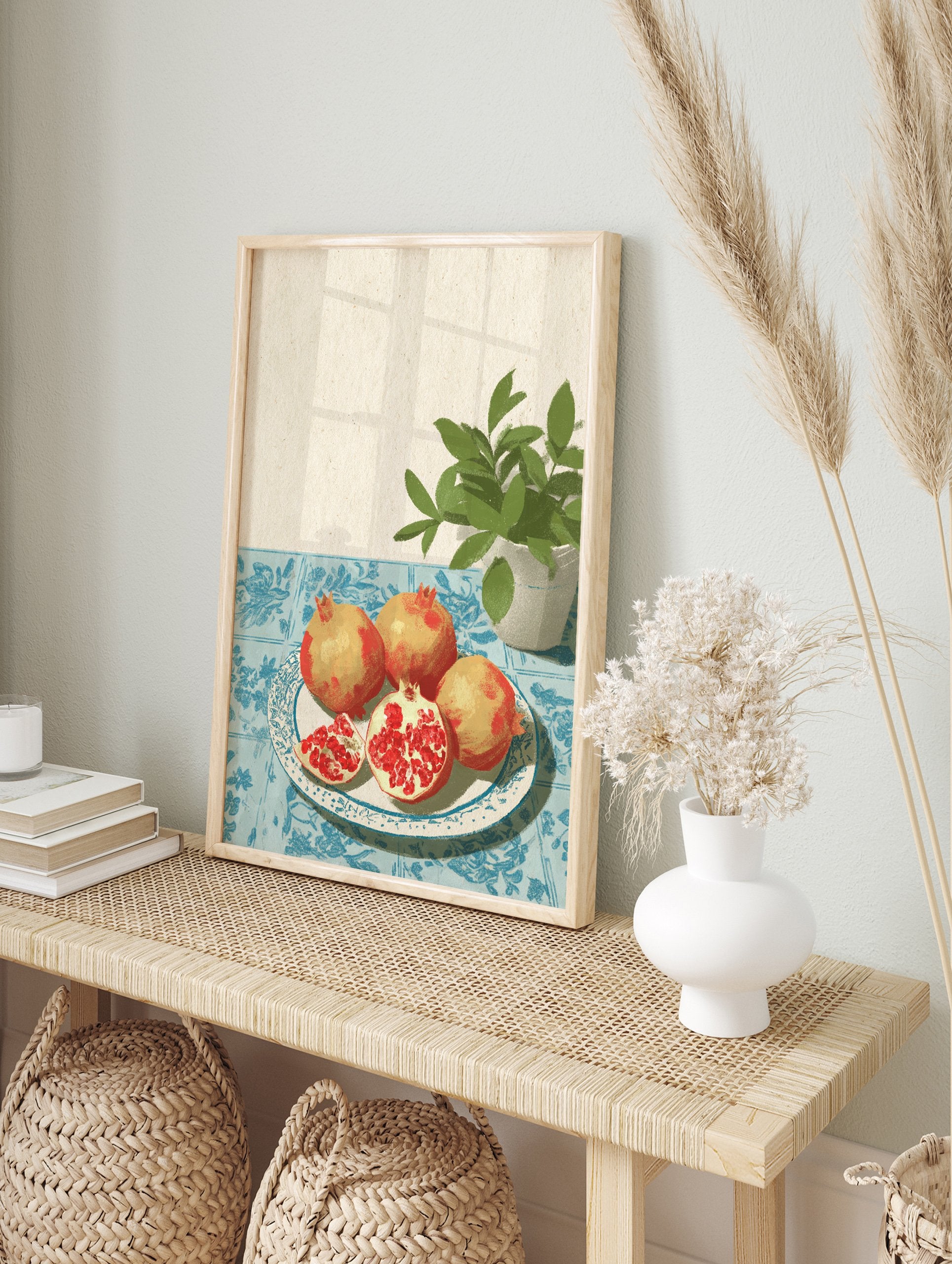Illustrative pomegranate wall art with whole and sliced pomegranates on a plate, blue tablecloth, and green plant. - Image 3