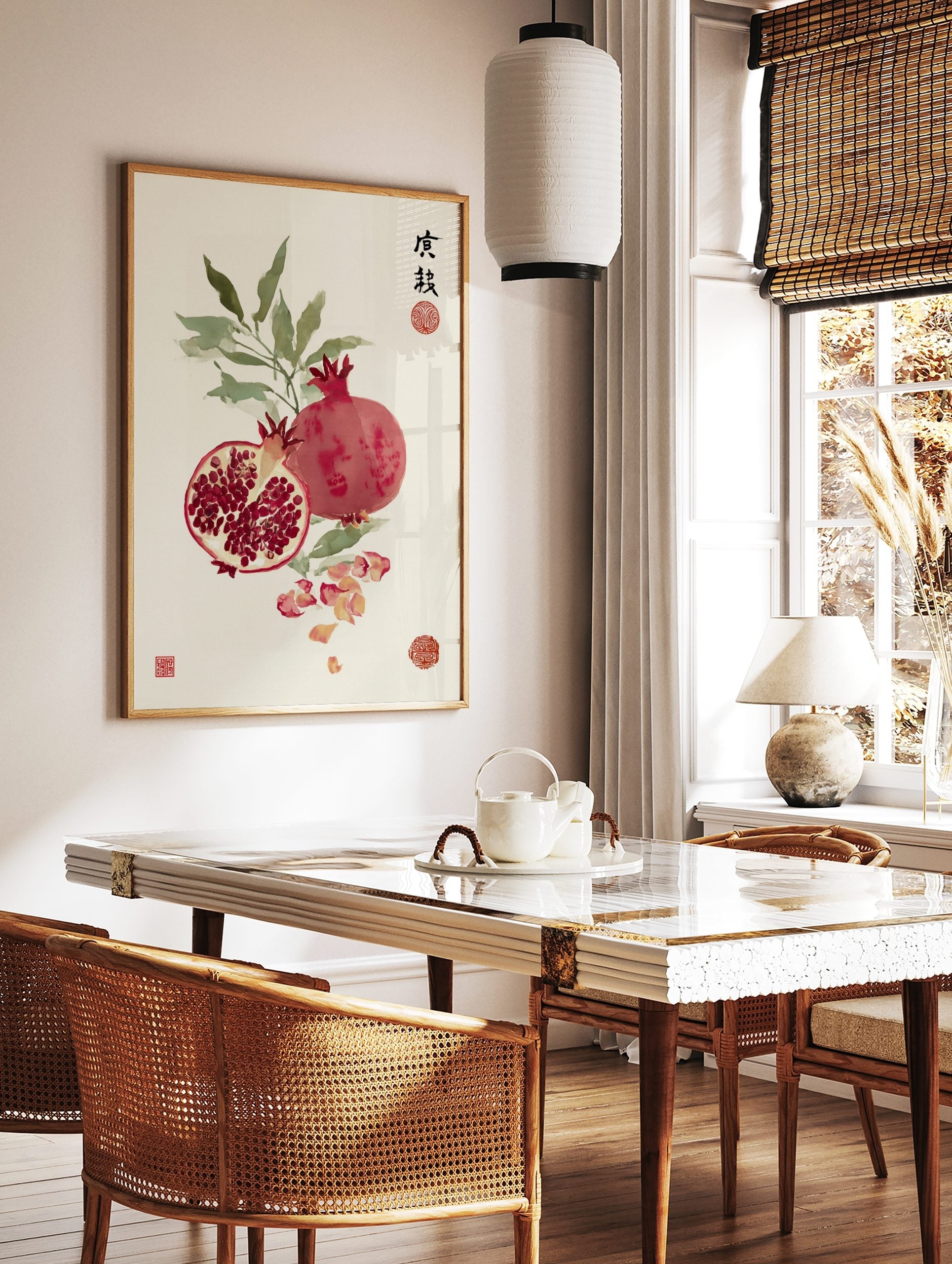 Pomegranate watercolour illustration with whole and cut fruit, green leaves, scattered petals, and, in a styled room mockup