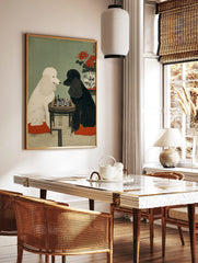 White and black poodles playing chess at a small table, with red spider lilies in a vase, in, in a styled room mockup