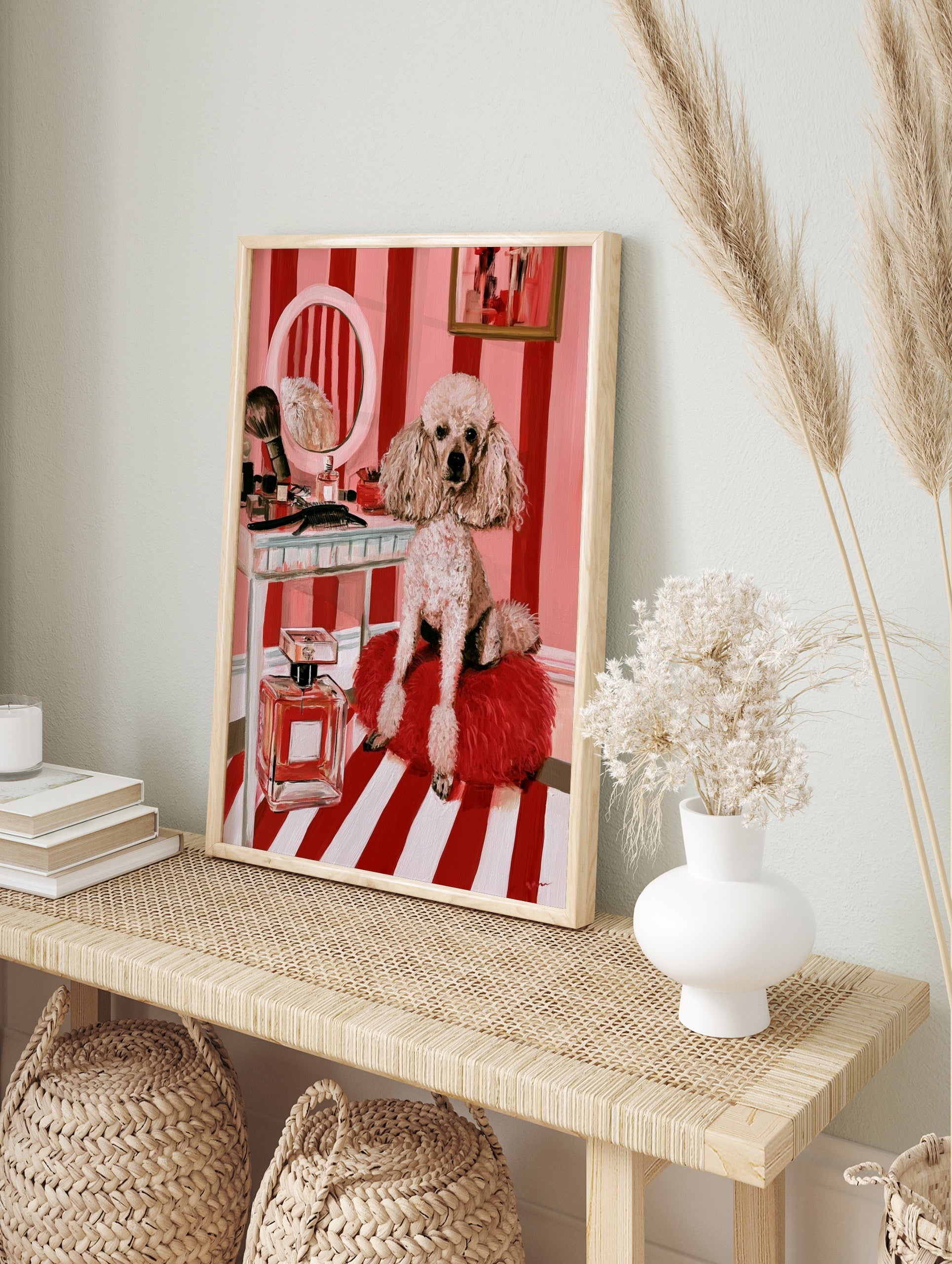 Illustrative print of a fluffy poodle on a red cushion before a vanity with a mirror and, in an alternate framed mockup