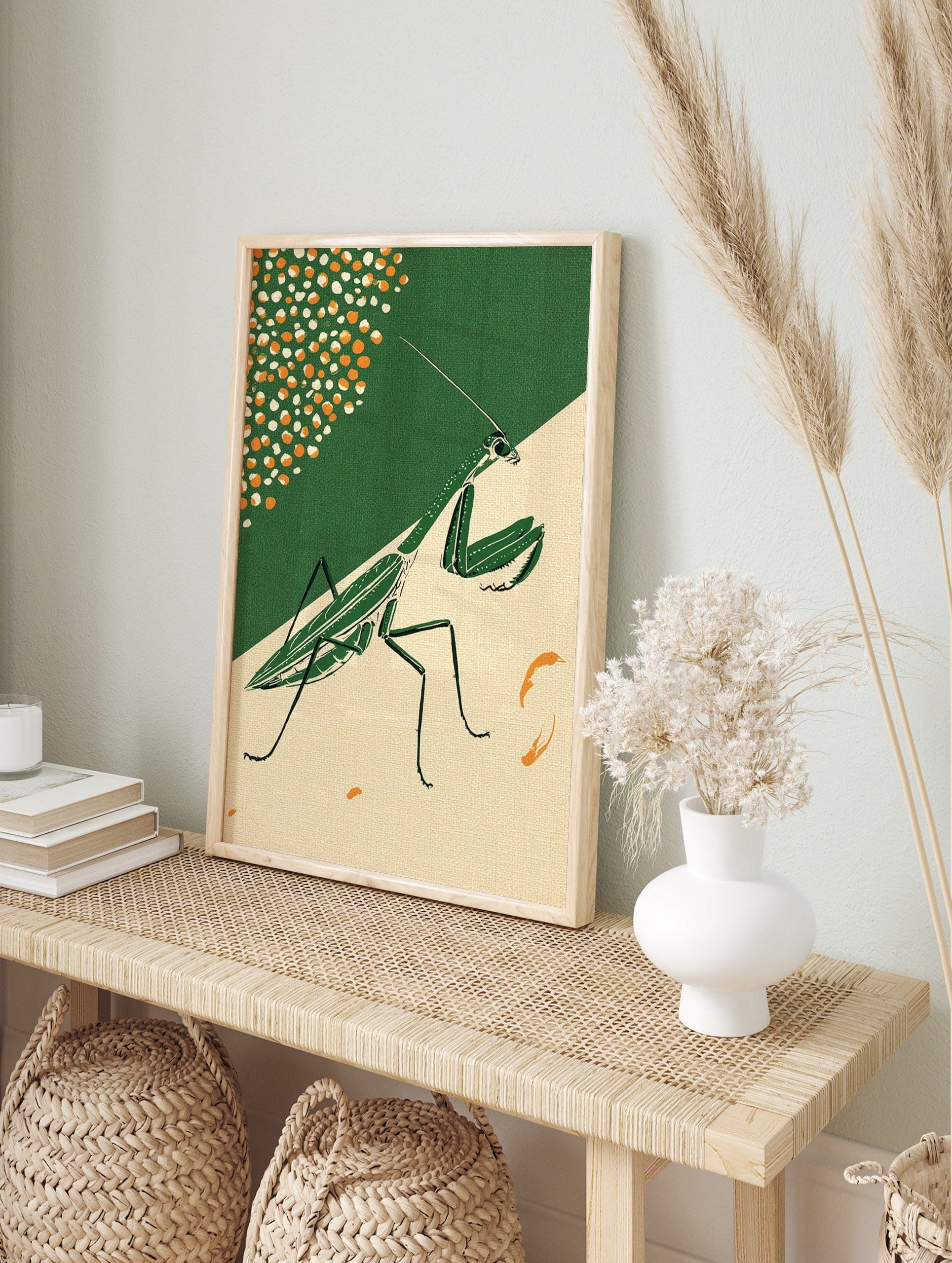 Illustrative praying mantis wall art in green on a split dark green and beige background with, in an alternate framed mockup