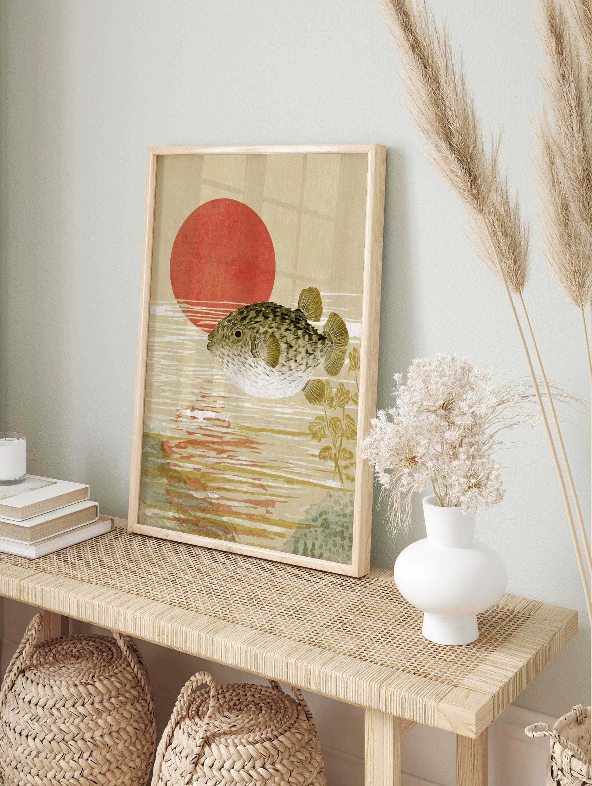 Pufferfish swimming in water with a large red sun in the background, Japanese woodblock style, in an alternate framed mockup