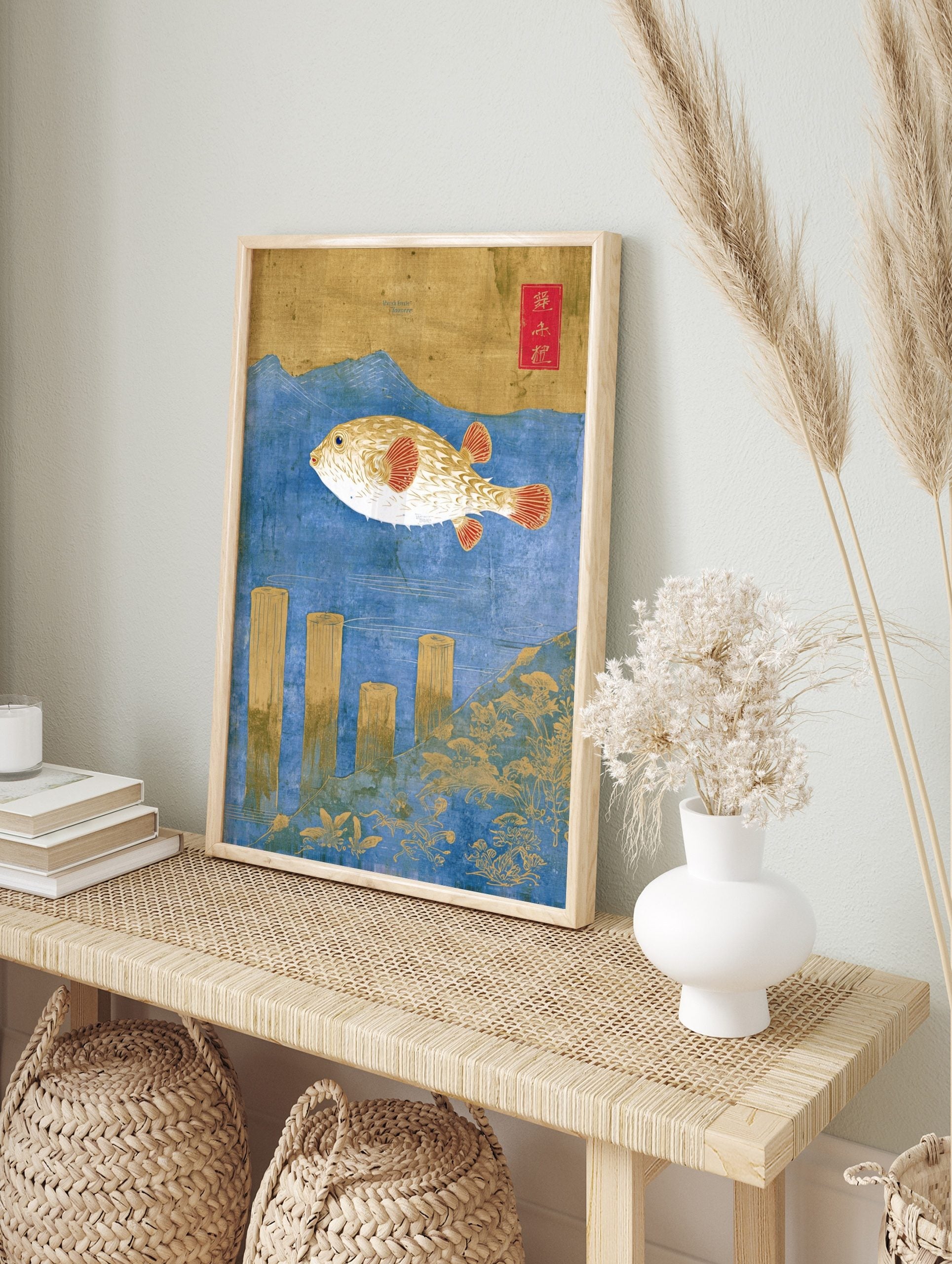 Ukiyo-e style pufferfish art print with gold fish, red fins, blue water, wooden posts, and, in an alternate framed mockup