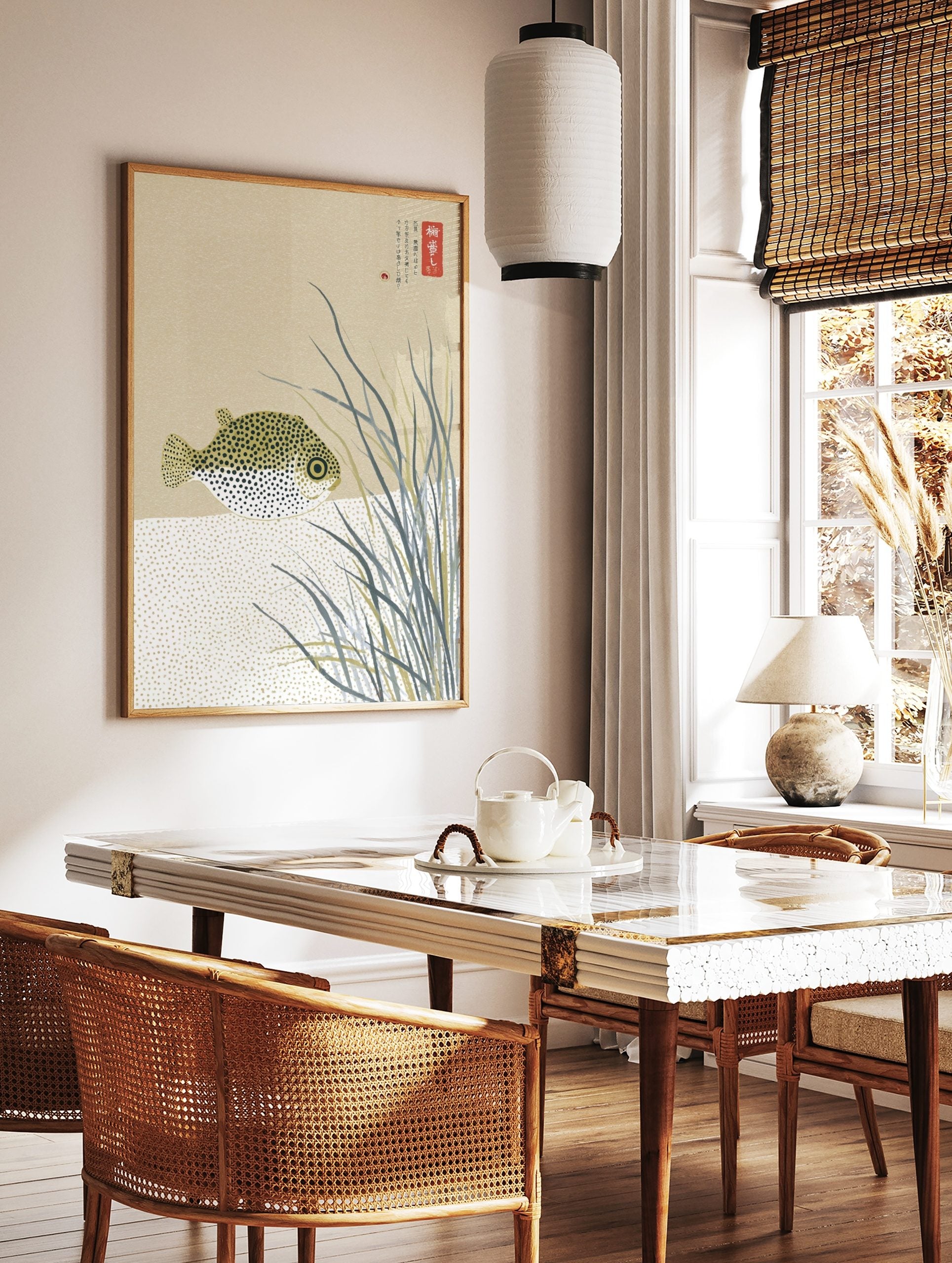 Illustrative pufferfish with black spots among tall grasses and Japanese text on a beige background, in a styled room mockup